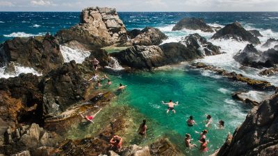 Visitors swimming in Arubas Natural Pool (Conchi), a volcanic rock basin in Arikok National Park