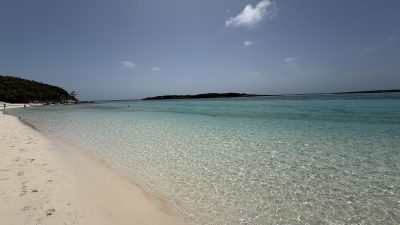 Empty white sand beach with calm, clear shallow water in the Bahamas
