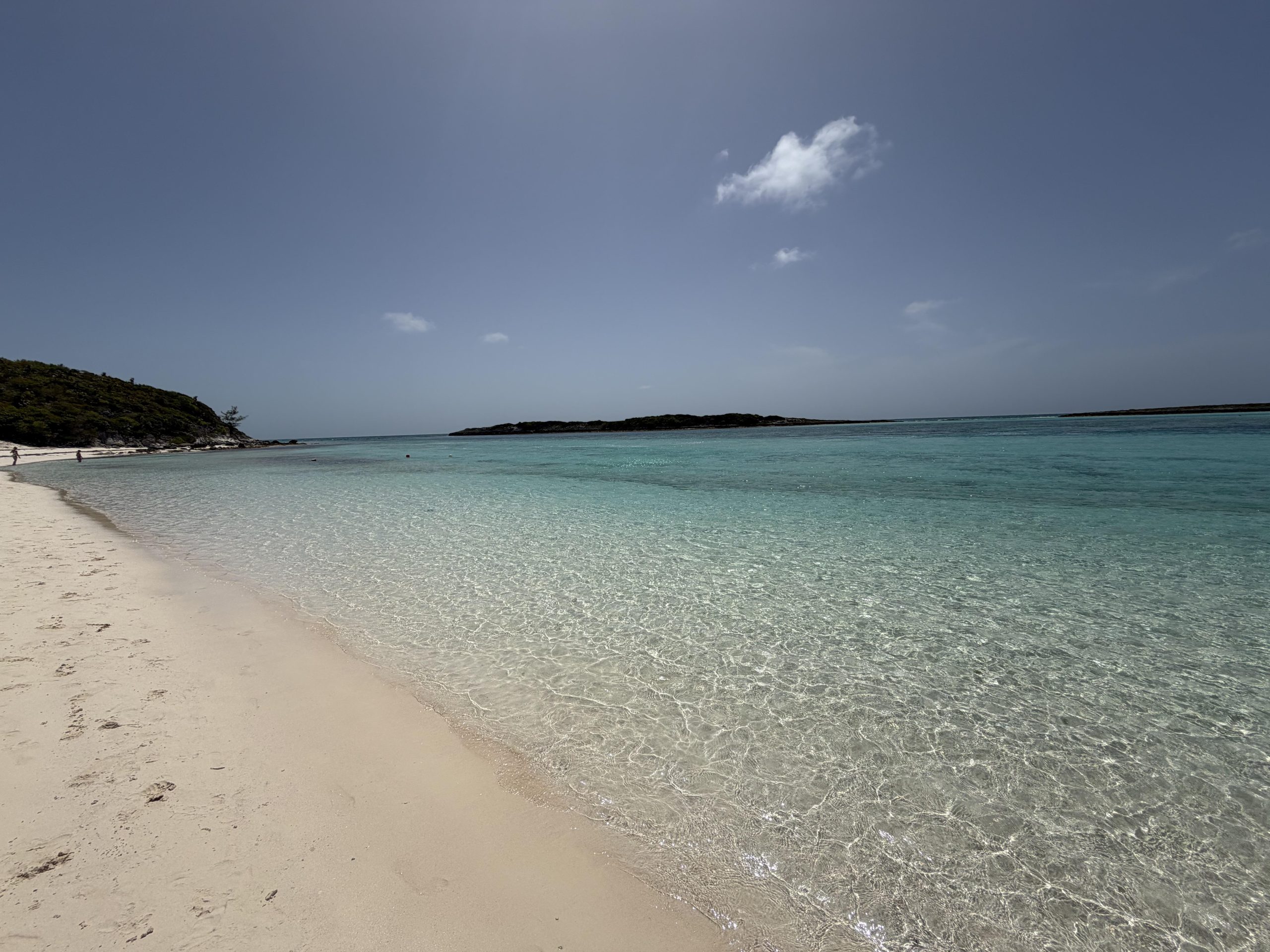 Empty white sand beach with calm, clear shallow water in the Bahamas