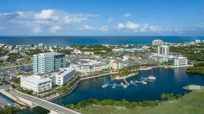 Aerial view of Camana Bay town center and marina in Grand Cayman, home to indoor cinema, museum, and play facilities