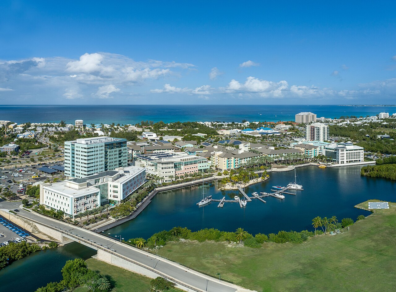 Aerial view of Camana Bay town center and marina in Grand Cayman, home to indoor cinema, museum, and play facilities
