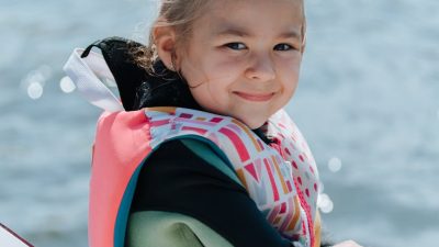 A young child wearing a properly fitted life jacket on a boat, the right water-safety gear choice for kids