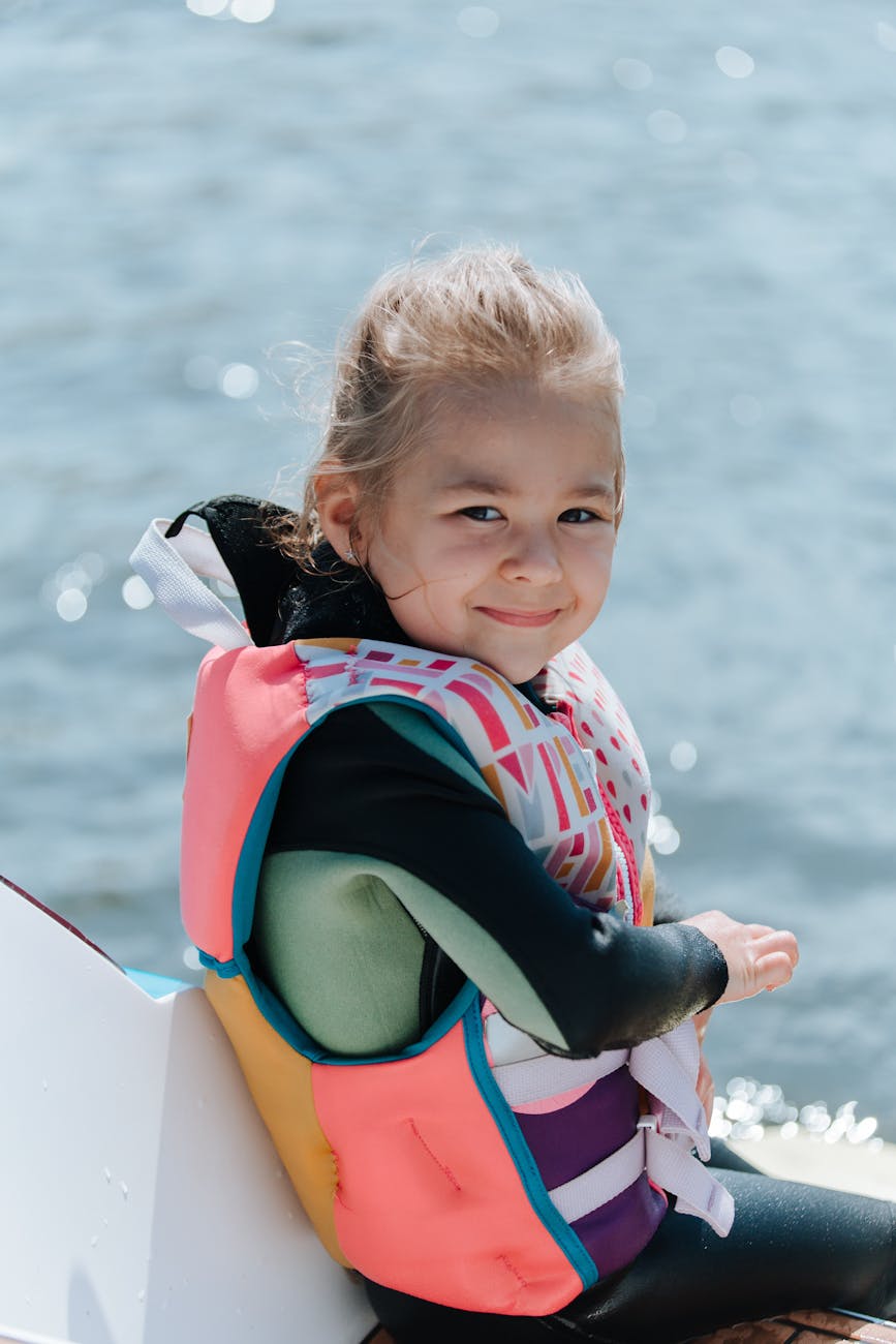 A young child wearing a properly fitted life jacket on a boat, the right water-safety gear choice for kids