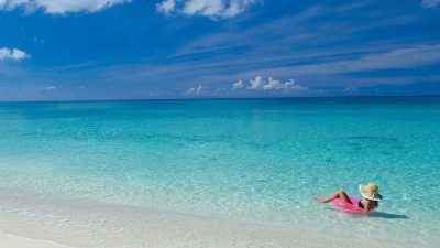 Calm, shallow turquoise water at Seven Mile Beach, Grand Cayman, with no visible surf