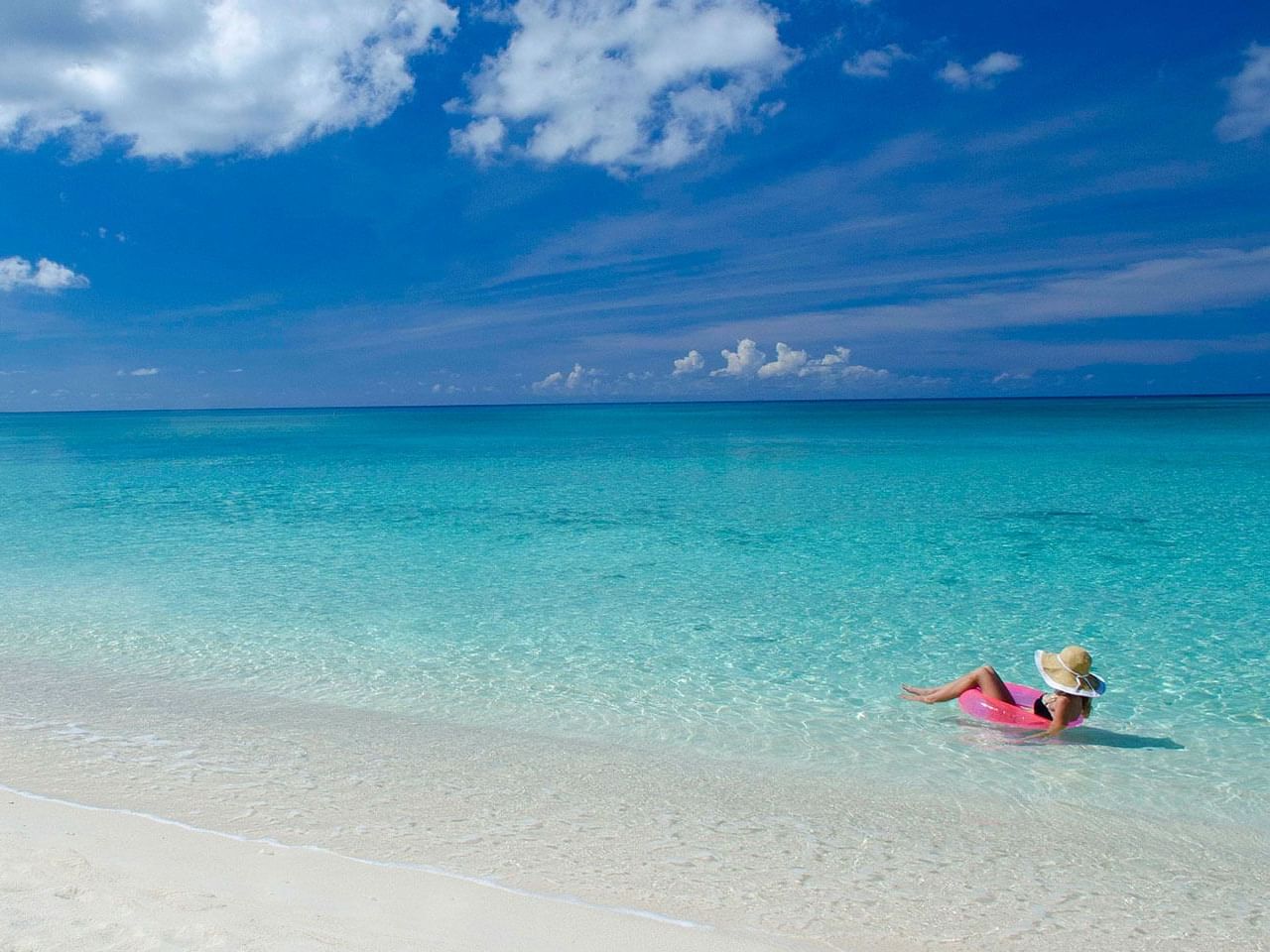 Calm, shallow turquoise water at Seven Mile Beach, Grand Cayman, with no visible surf