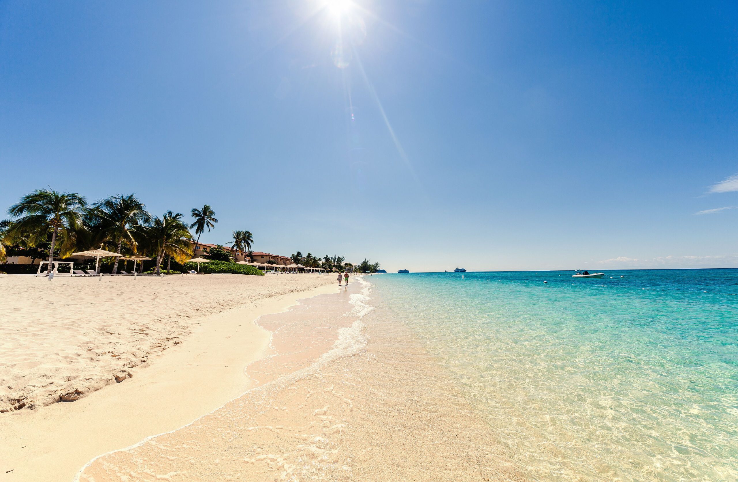 Sunny day on Seven Mile Beach, Grand Cayman, with clear turquoise water and palm trees