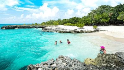 Families wading and snorkeling in the shallow protected cove at Smith Cove, Grand Cayman