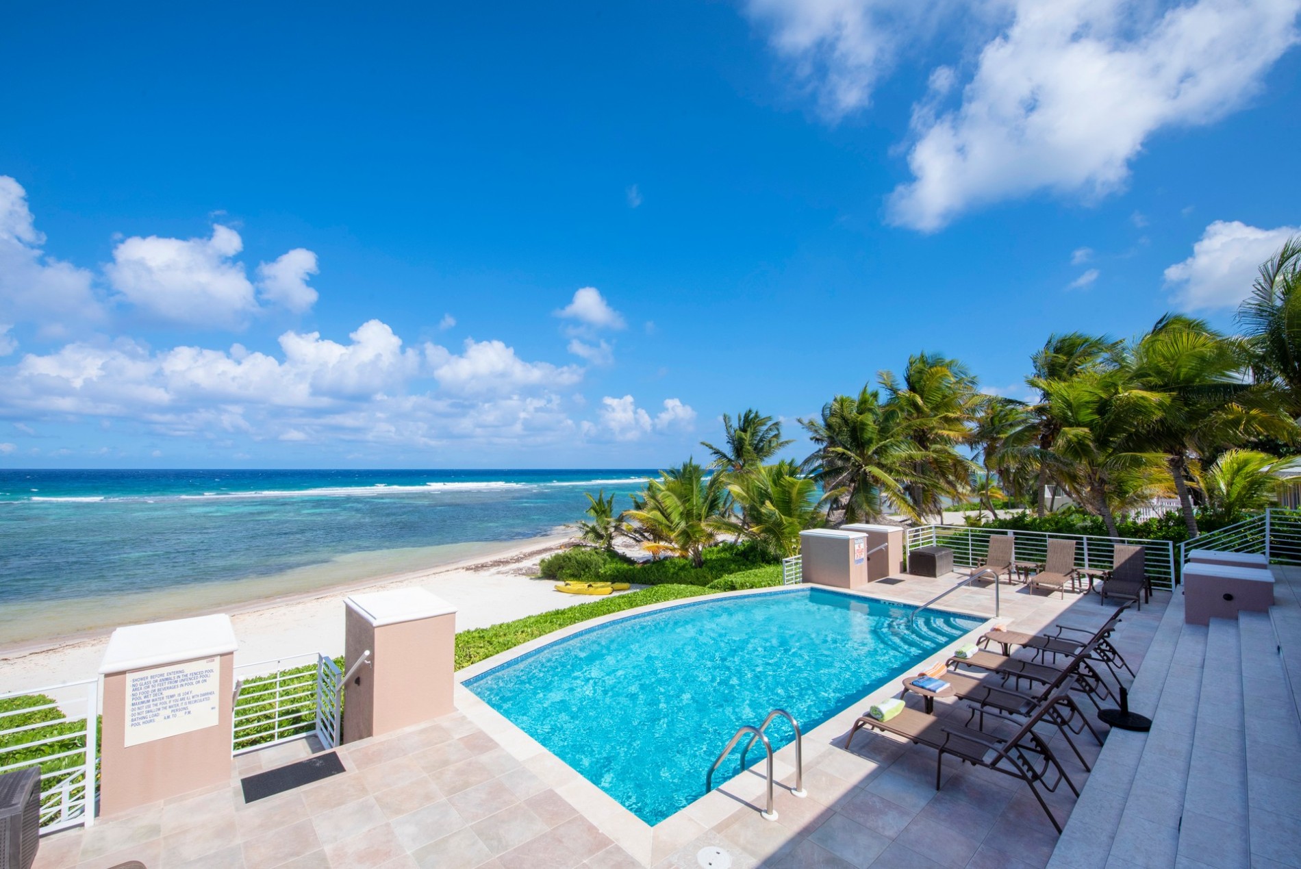 A beachfront villa private pool overlooking the ocean in Grand Cayman, the kind of layout that suits a multigenerational family trip