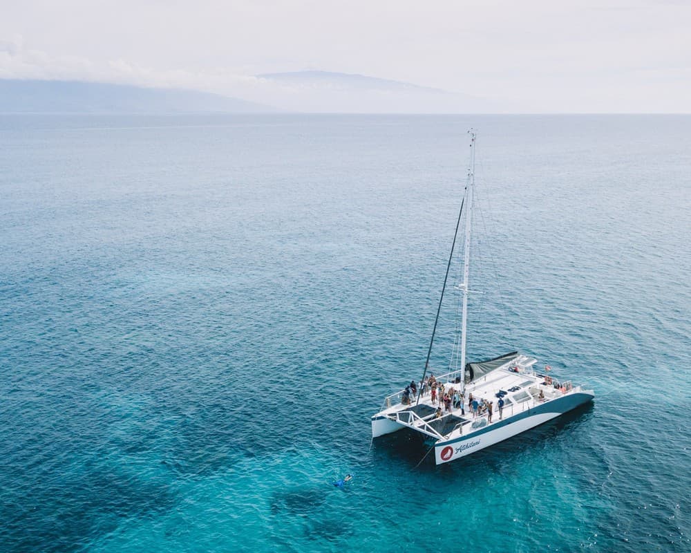 Snorkel catamaran anchored in clear turquoise water off Maui