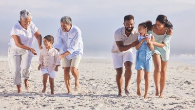 Three generations of a family walking together on a beach