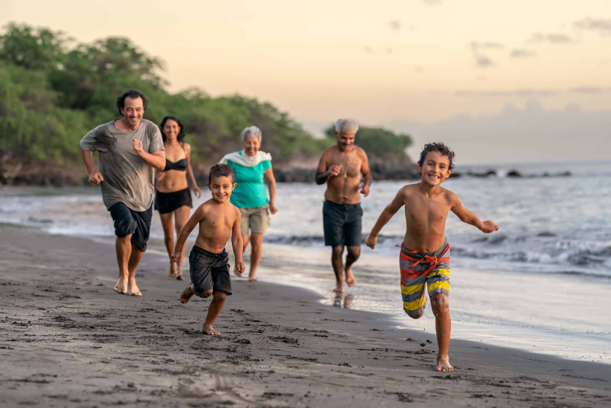 Multiple generations of a family running together on a beach