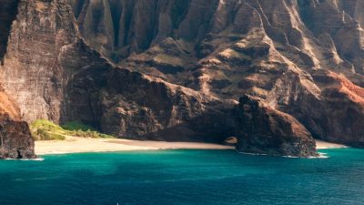 Catamaran boats along Na Pali Coast cliffs Kauai