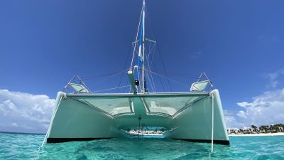 Catamaran anchored in shallow turquoise water off a St Martin beach