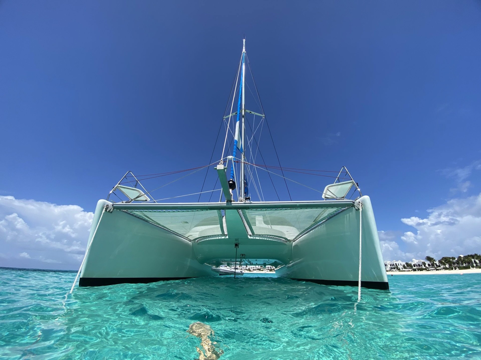 Catamaran anchored in shallow turquoise water off a St Martin beach
