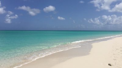 Empty stretch of Grace Bay Beach, Providenciales, with turquoise water and white sand, free and open to the public