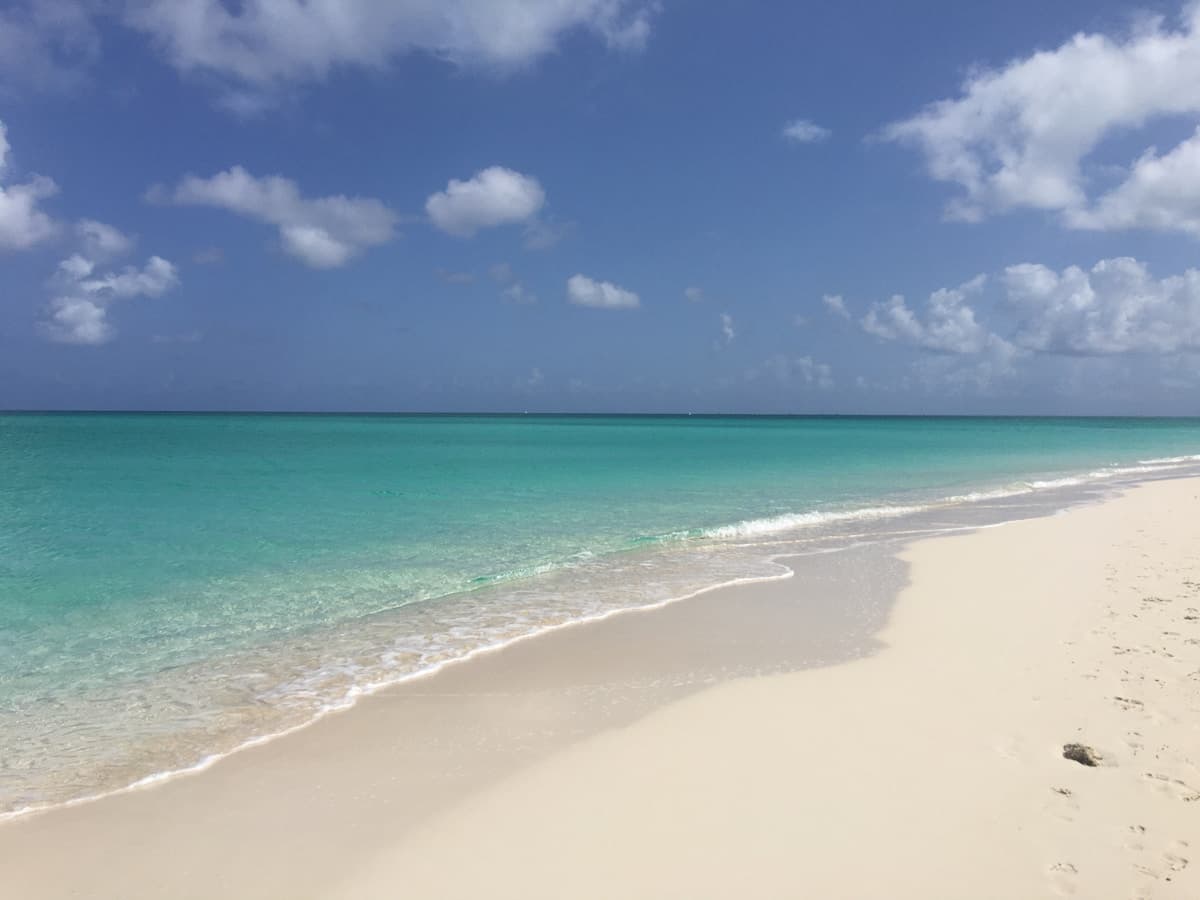 Empty stretch of Grace Bay Beach, Providenciales, with turquoise water and white sand, free and open to the public